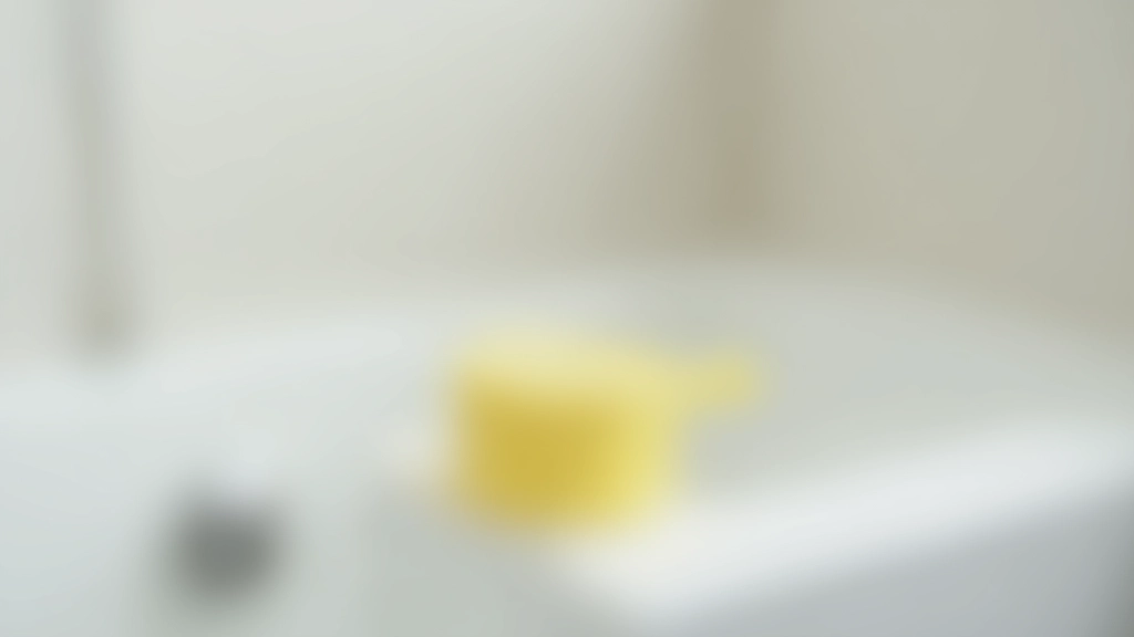 Déboucheur à ventouse jaune sur bord de baignoire, tuyau d'eau en arrière-plan, salle de bain carrelée